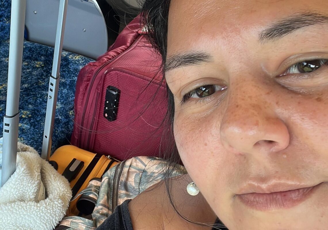 Fernanda Saad em um trem, cercada por malas, simbolizando a jornada de superação, determinação, propósito e busca por uma vida autêntica.